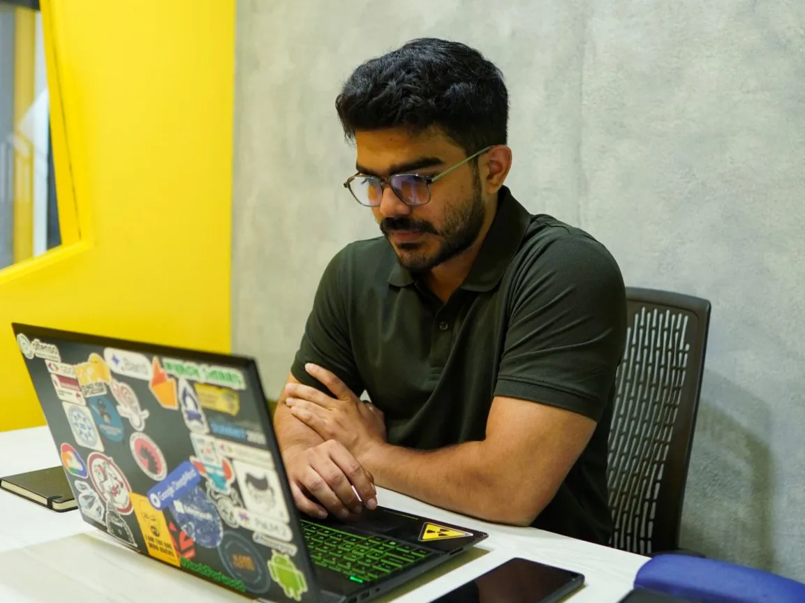 Me at work as CTO, at my sticker-covered laptop